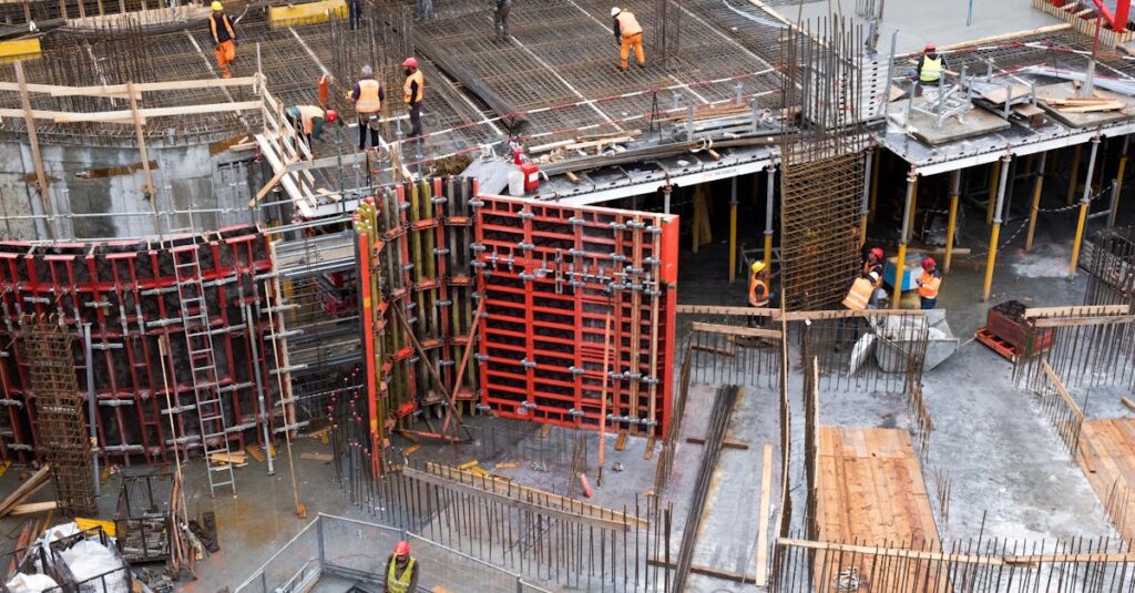 Industrial construction site with workers in high visibility clothing at a steel framework structure.