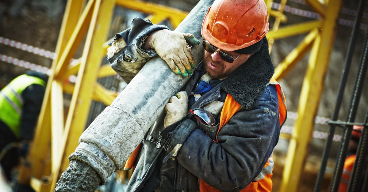 Construction worker in safety gear handling equipment on an active site.